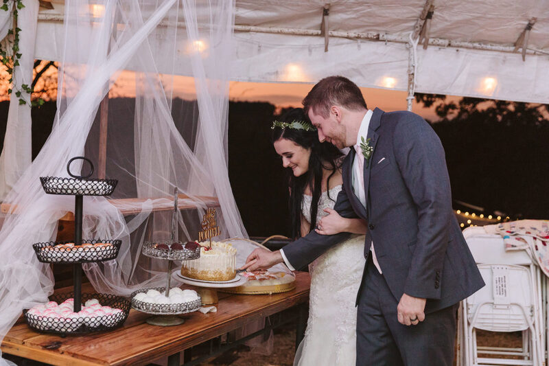 The bride and groom cut the cake at the outdoor venue at Dockley Ranch